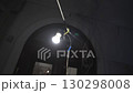 Hanging bulb on wire illuminates room with high ceilings 130298008