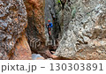 Climber on via ferrata trail, crossing a deep canyon. 130303891