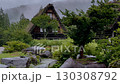 白川郷の合掌造りと庭園の石、雨の日の静かな風景 130308792