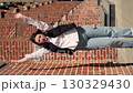 young woman dances joyfully down a city street, her hands elegantly moving and her face beaming with happiness. This scene captures the essence of carefree and spirited dance in an urban setting. 130329430