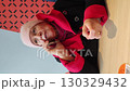 Elderly woman talking on the phone at a table. Represents communication, connection, and staying in touch. 130329432