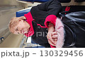 Senior woman in a winter coat riding on a train. Highlights transportation, travel, and city life. 130329456