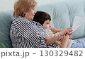 Elderly woman and young boy discussing a paper together. Represents education, support, and quality family time. 130329482
