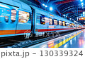 A high-speed train gliding through a modern station at night, showcasing vibrant lights and a bustling atmosphere. 130339324