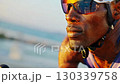 A determined cyclist racing on a sunlit road, showcasing strength and focus while wearing protective gear in a vibrant outdoor setting. 130339758