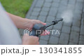 Close up of young woman wash clean path with pressure washer in the backyard. 130341855
