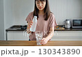 グラスに炭酸水を注ぐ女性 130343890