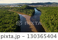 River confluence in a lush forested area near a small town during daylight 130365404