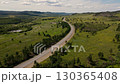 Explore the winding road through lush greenery in beautiful countryside 130365408