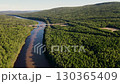 Breathtaking river winding through dense forest in a serene landscape 130365409