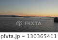 Sunset view over calm water with boat near coastal landscape 130365411