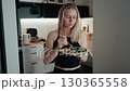 Woman eating fresh salad in kitchen, healthy vibe defines modern lifestyle, healthy energy flows through every detail, healthy choice appeals to fitness and wellness projects. Woman savoring salad 130365558