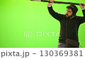 Boom microphone operator testing sound at TV studio on green key chroma background. 130369381