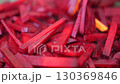 A pile of red carrots are in a pan. The carrots are cut into small pieces and are cooked in a pan. 130369846