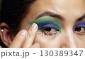 Applying vibrant pink and purple eyeshadow with a blending brush close up view	 130389347