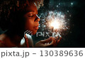 Child experiences wonder while holding a sparkler and making wishes during a nighttime celebration 130389636