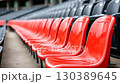 Bright red stadium seats arranged in neat rows at an outdoor sports venue before a major event begins 130389645