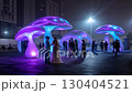 A group of people standing in front of a group of illuminated mushrooms 130404521