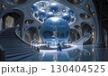 A woman standing in a room filled with lots of blue spheres 130404525