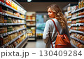 A woman exploring the vibrant aisles of a grocery store filled with colorful products and fresh produce. 130409284