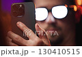 Man with anime glowing glasses swiping on smartphone 4K 130410515