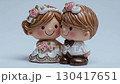 幸せそうにキスをする新郎新婦のケーキトッパー人形が、白い背景の前でゆっくりと回転する可愛らしい映像。 130417651