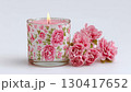 白い背景に置かれたピンクの花と、炎が優しく揺らめく花柄のアロマキャンドルの癒やしの映像。 130417652