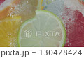 Bright slices of grapefruit, lime, lemon, and orange are immersed in sparkling water, creating a vibrant 130428424