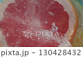 Freshly sliced grapefruit revealing vibrant segments and juicy texture on a colorful background 130428432