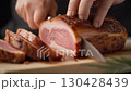 ロースハムを包丁で切っている様子 130428439