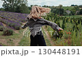 Happy young blonde woman with sunglasses and open checked shirt feeling free, spinning around and enjoying nature in beautiful lavender field. Blonde joyfully through blooming lavender landscape 130448191