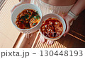 Woman wearing pajamas offering spicy eggs in bowl, culinary elegance highlights modern dining, culinary concept sparks creative vision, culinary imagery suits lifestyle and gastronomy branding 130448193