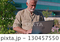 Focused senior man working on laptop in outdoor 130457550