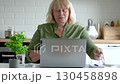 Mature woman experiencing problems with laptop working remotely from home, showing expressions annoyance and stress. Fatigue working on laptop. Old people working. Frustration and business failure 130458898