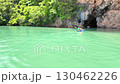 Tourists in canoeing enter a cave of a limestone cliff Tourists in canoeing enter a cave of a limestone cliff 130462226
