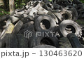 In an area overwhelmed by discarded rubber tires, serious ecological issues arise as improper disposal leads to environmental disturbance and pollution. The situation highlights urgent concerns. 130463620