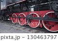 Experience the charm of a vintage steam locomotive as it stands proudly at a historical railway station, featuring intricate wheels and classic mechanics reminiscent of the early 1900s. 130463797