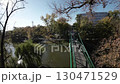 A first-person view FPV flight through a park. The video starts in a square with a monument in the center. The camera then flies through the park, passing by trees, bushes, and a pond. The video ends 130471529