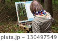 An artist paints nature in a park.  130497549