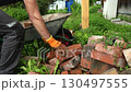 A bricklayer puts bricks in a cart.  130497555