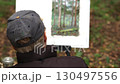 An artist paints nature in a park.  130497556