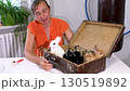 Woman plays and feeds cabbage to three colorful mini rabbits 130519892
