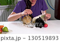 In the background of the woman are three decorative mini rabbits at the table. 130519893