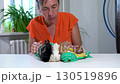 A woman dries three decorative miniature rabbits with a towel. 130519896