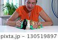A woman dries three decorative miniature rabbits with a towel. 130519897