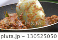 A close up shot of a hand stirring savory beef rendang in a pan. This traditional Indonesian cuisine is slow cooked with spices until tender, perfect for food, travel, or culture projects. 130525050