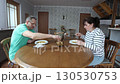 Family couple eats pumpkin soup with croutons at dining table enjoying cozy meal together in warm home atmosphere. 130530753