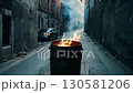 Burning barrel in narrow street with parked car 130581206