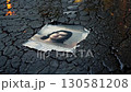 Damaged photograph of a young man lying on wet asphalt 130581208