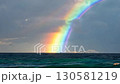 Double rainbow appearing on the horizon of a wavy ocean 130581219